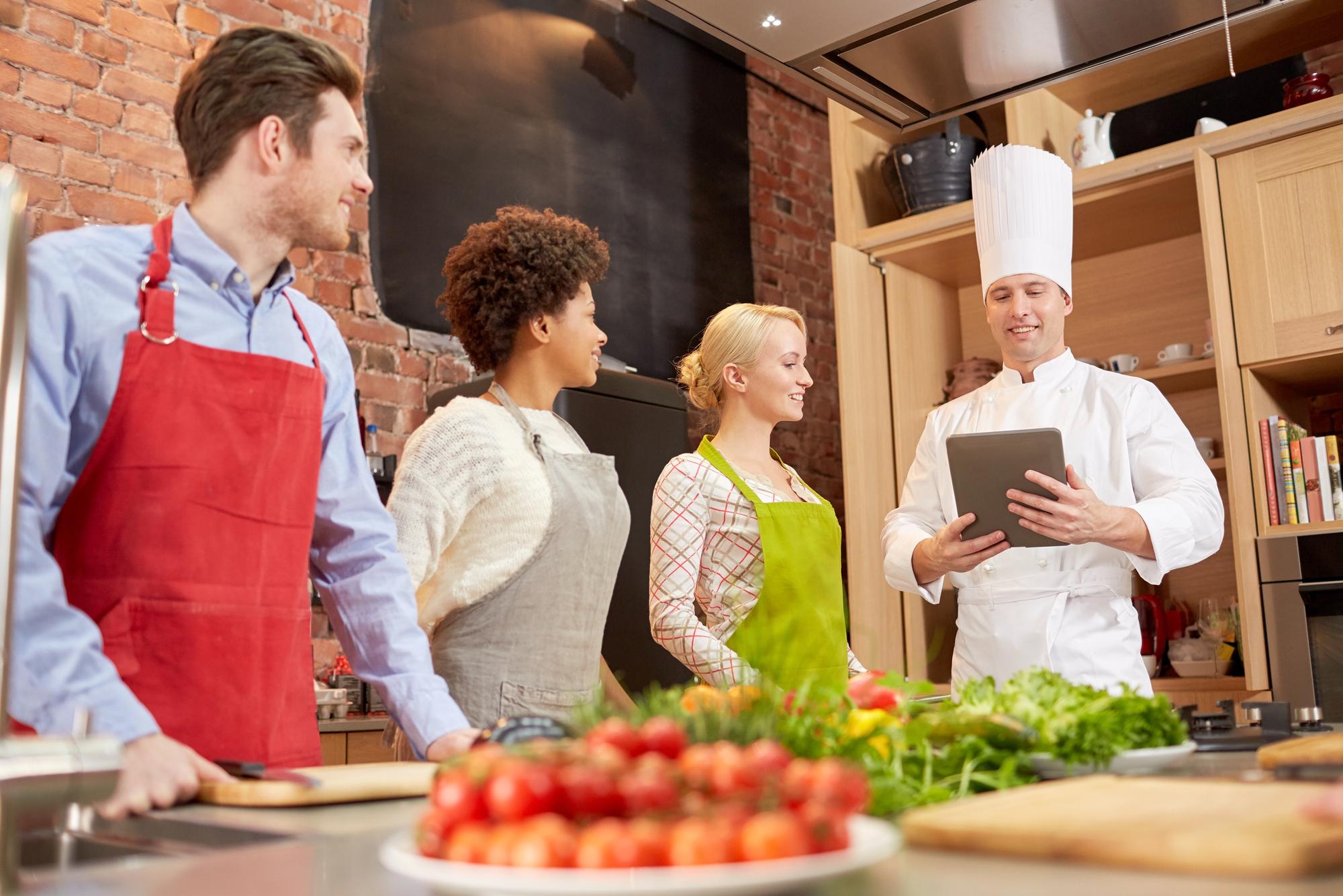 Consultant discussing menu with chef in kitchen